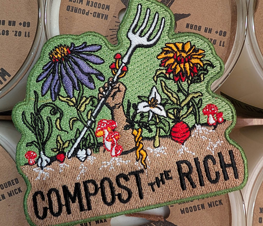 An embroidered "Compost the Rich" patch spotted at the venue